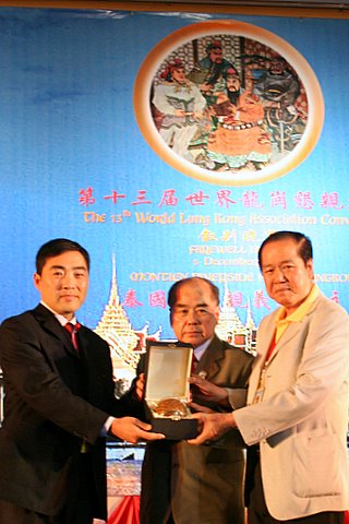 关公网站长关志杰接过泰国龙冈张永吉会长(中)和刘锦庭副会长(右)赠送的纪念礼品（关乐声摄影） 